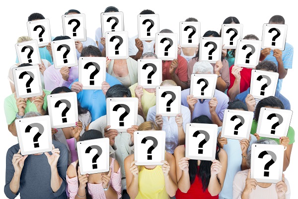group of people each holding a ? in front of their face
