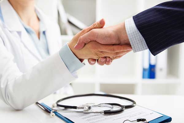Two people shaking hands over completed paperwork
